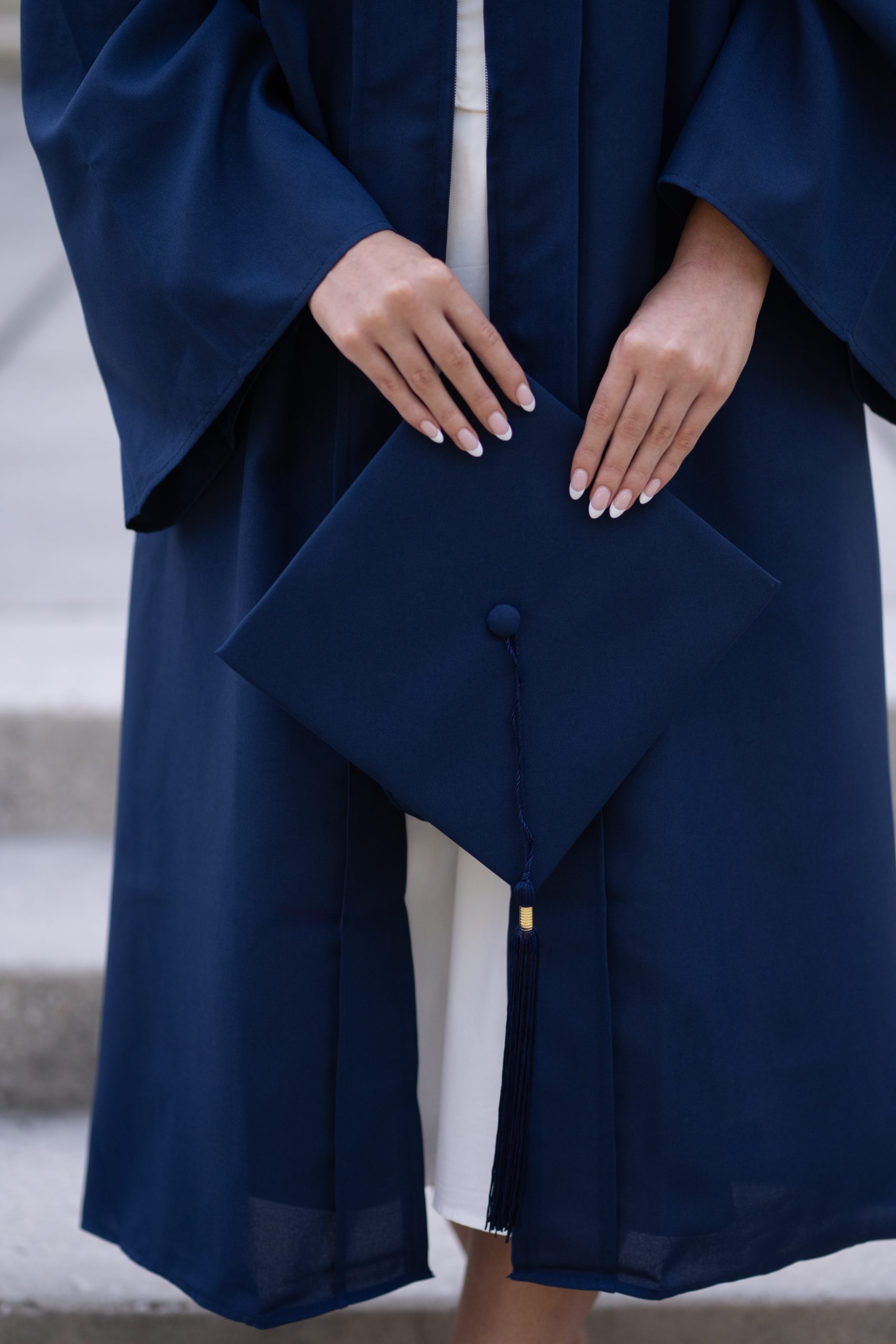 Graduation Front of graduation gown with hands holding grad cap in front
